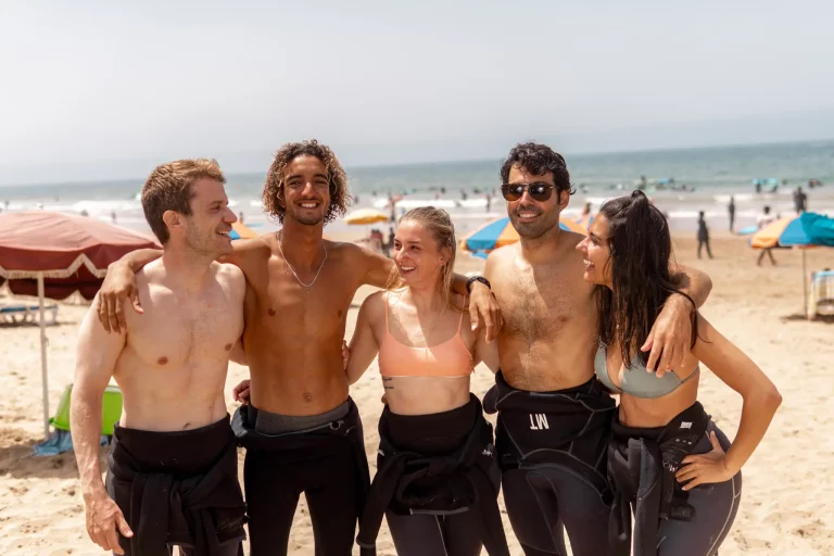 A picturesque beach in Taghazout with surfers catching waves at a Taghazout surfcamp