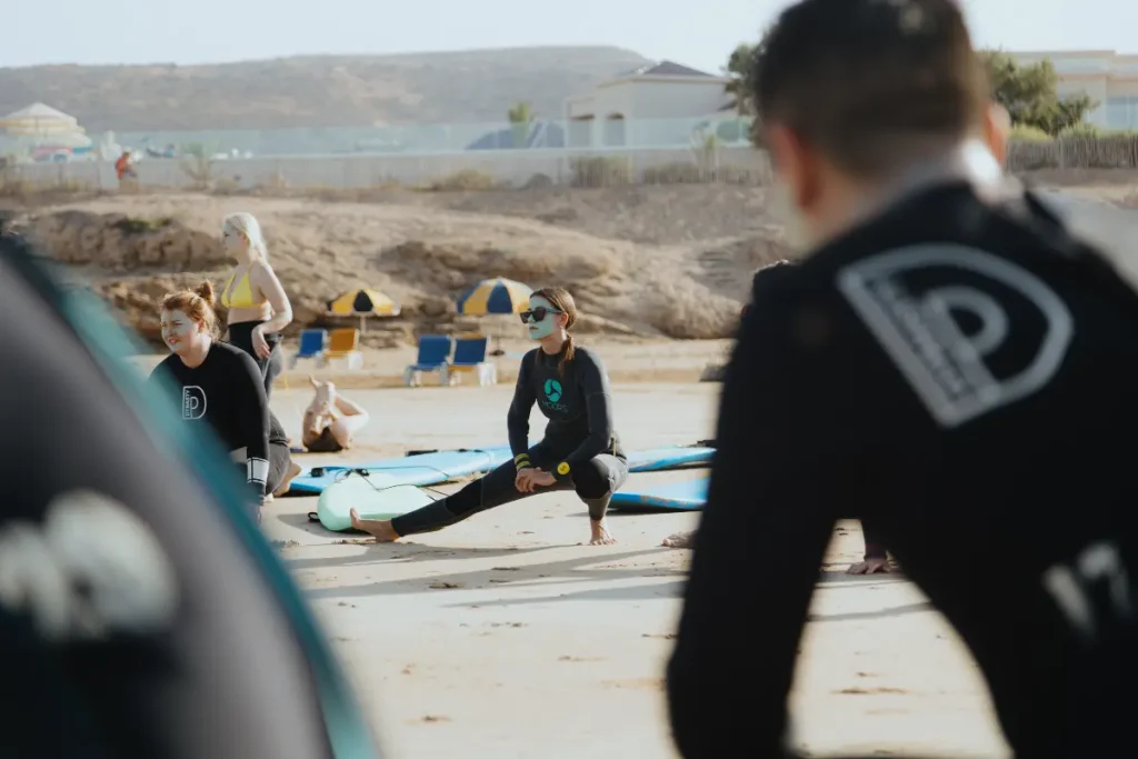 Las clases de surf en Taghazout empiezan con calentamiento y estiramientos en la playa