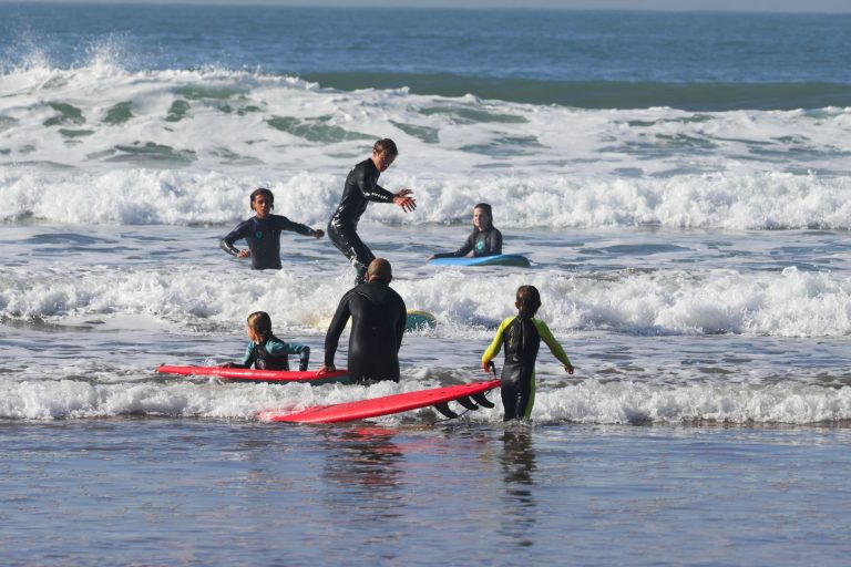 Surf camp familial à Taghazout : enfants et parents surfent ensemble dans la mousse