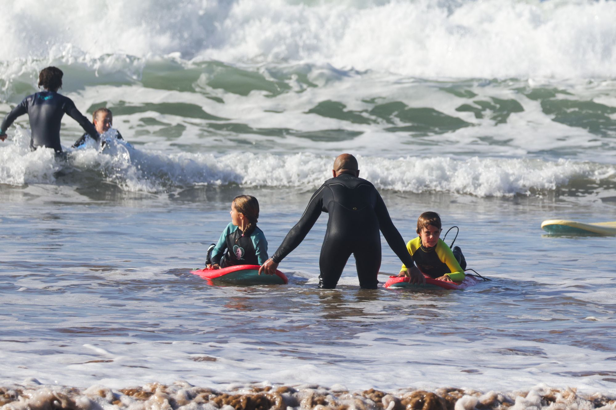 surf instructor pushing kids into waves | Twist Surf